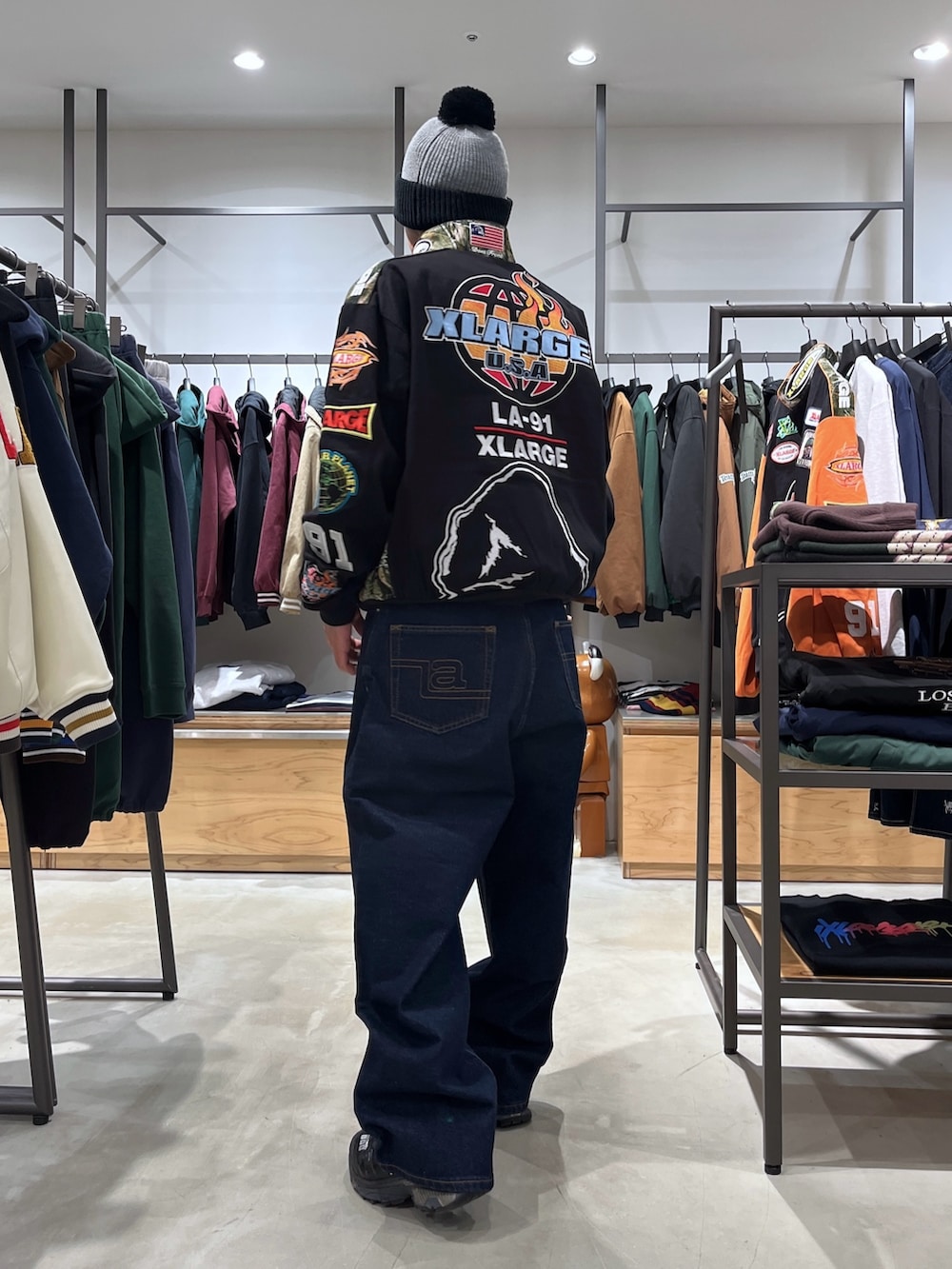 ブラック系のブルゾン、ブルー系のデニムパンツ、グレー系のニットキャップ/ビーニーを着用したメンズの秋コーディネートの4枚目の写真