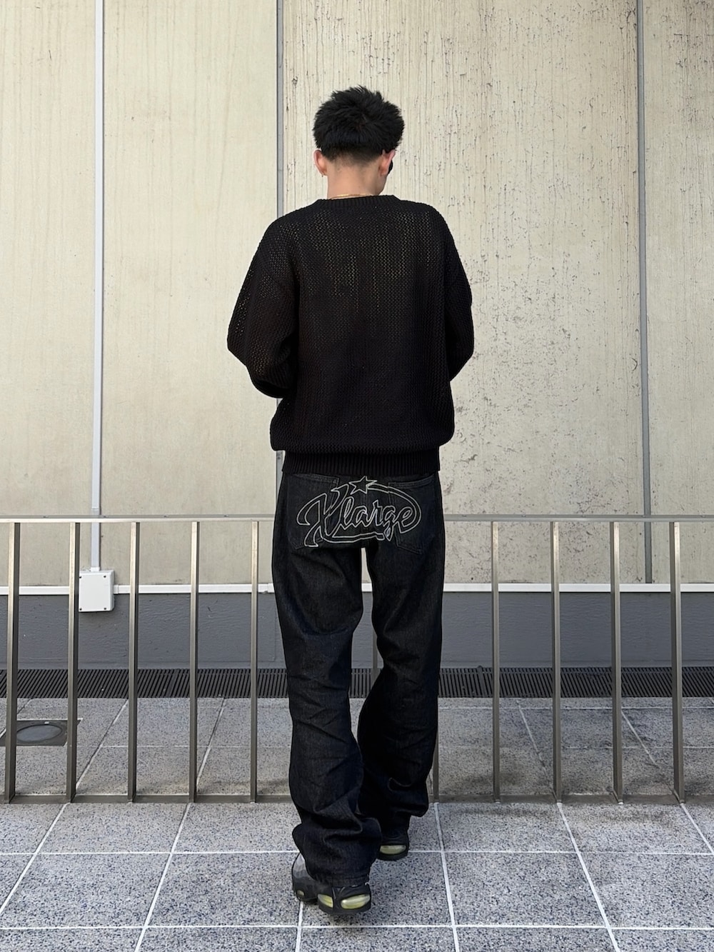 ブラック系のニット/セーター、ブラック系のデニムパンツを着用したメンズの春コーディネートの4枚目の写真