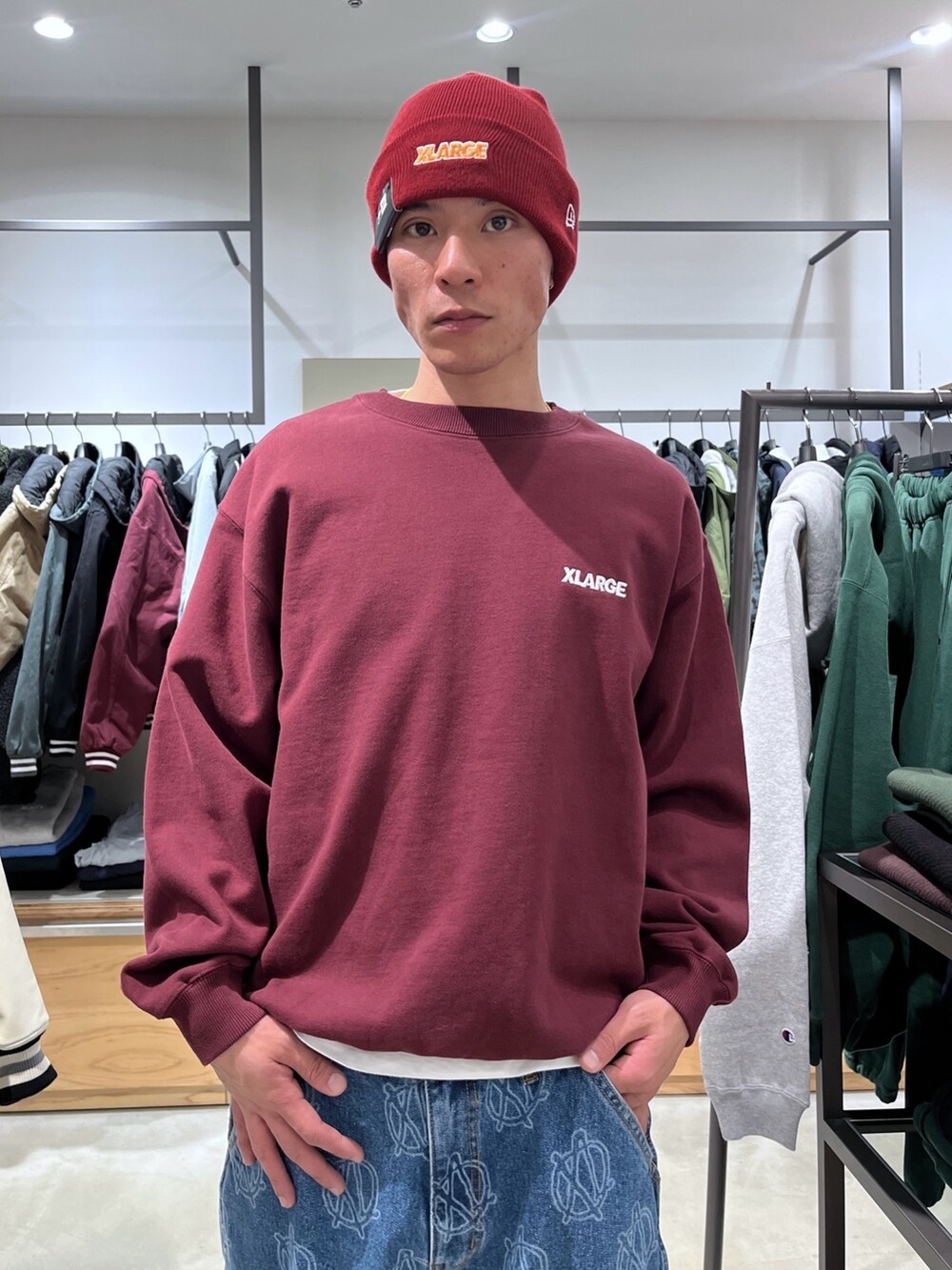 レッド系のスウェット、ブルー系のデニムパンツ、レッド系のニットキャップ/ビーニーを着用したメンズの冬コーディネートの7枚目の写真
