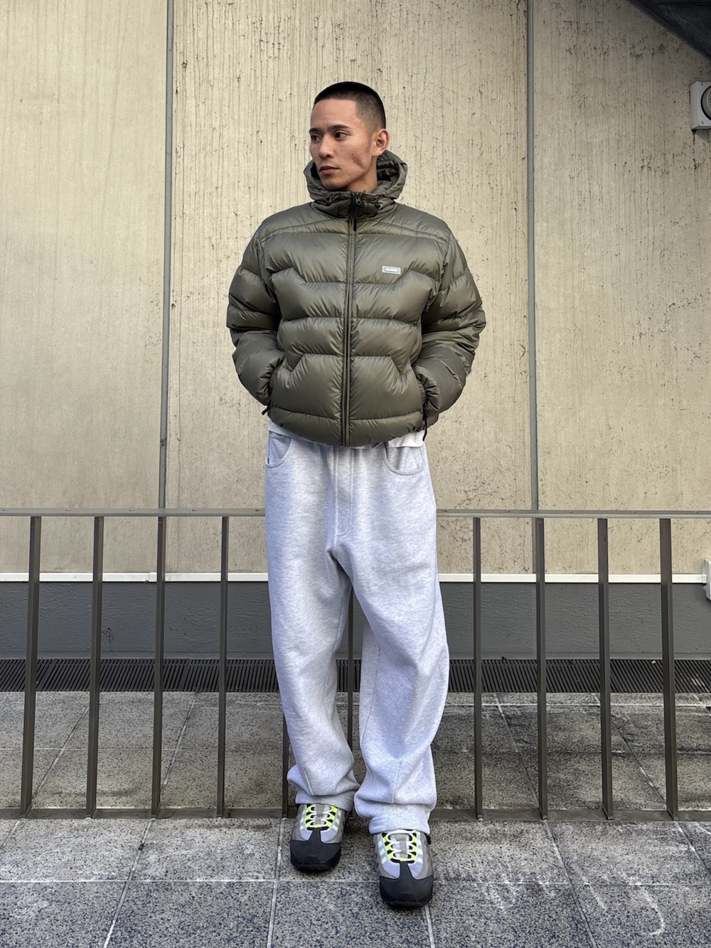 グリーン系のダウンジャケット/コート、グレー系のスウェットパンツを着用したメンズの冬コーディネートの2枚目の写真