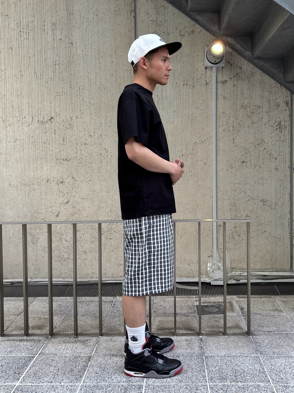 ブラック系のTシャツ/カットソー、ブルー系のその他パンツ、ホワイト系のキャップを着用したメンズの春コーディネートの4枚目の写真