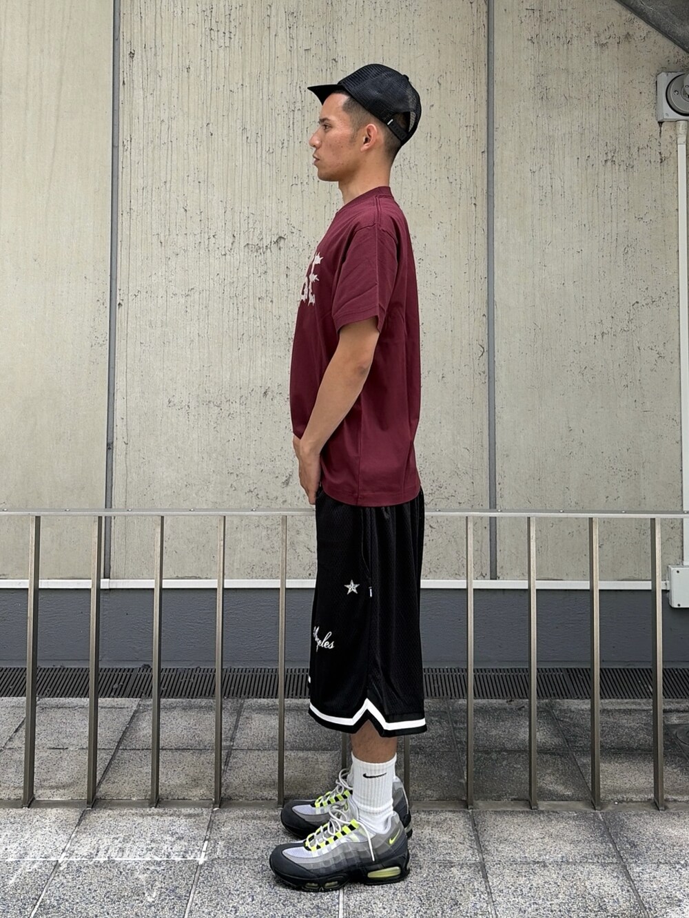 レッド系のTシャツ/カットソー、ブラック系のその他パンツ、ブラック系のキャップを着用したメンズの夏コーディネートの2枚目の写真