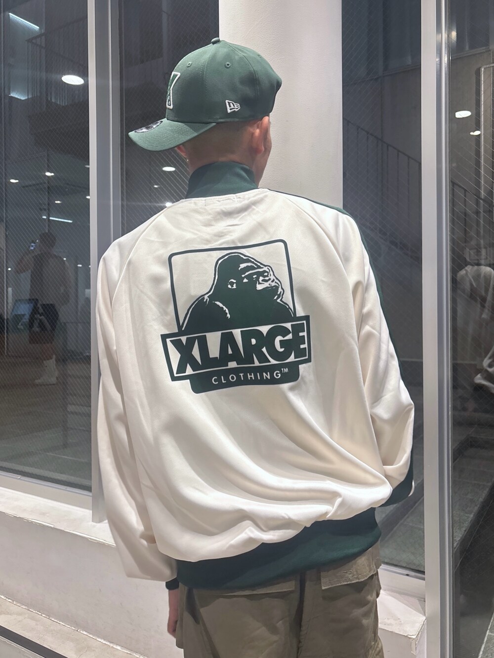 ホワイト系のブルゾン、グリーン系のカーゴパンツ、グリーン系のキャップを着用したメンズの秋コーディネートの7枚目の写真