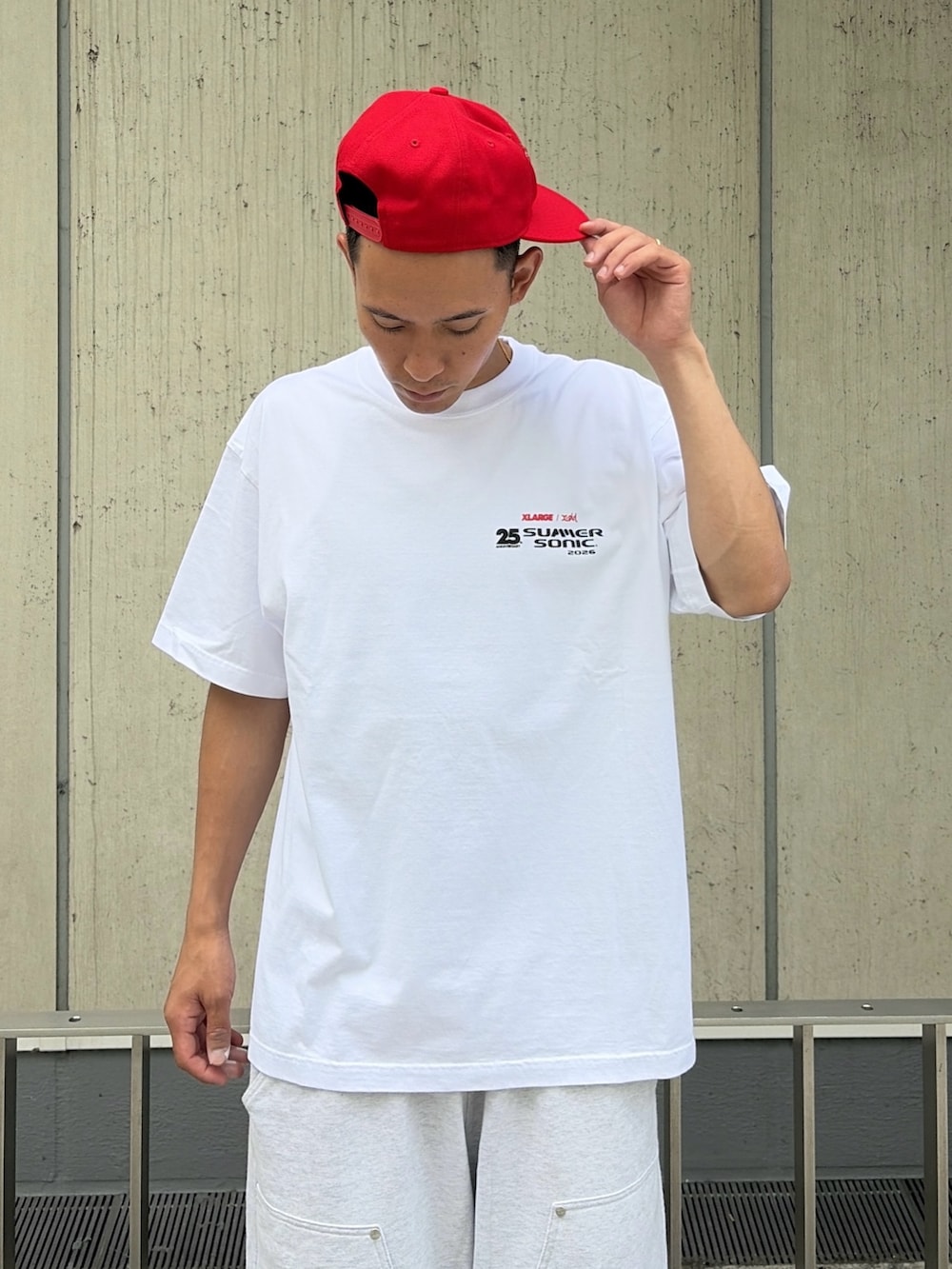グレー系のスウェットパンツ、レッド系のキャップを着用したメンズの夏コーディネートの9枚目の写真