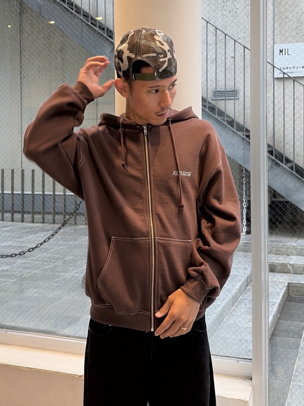 ブラウン系のパーカー、ブルー系のデニムパンツ、ブラック系のキャップを着用したメンズの秋コーディネートの7枚目の写真