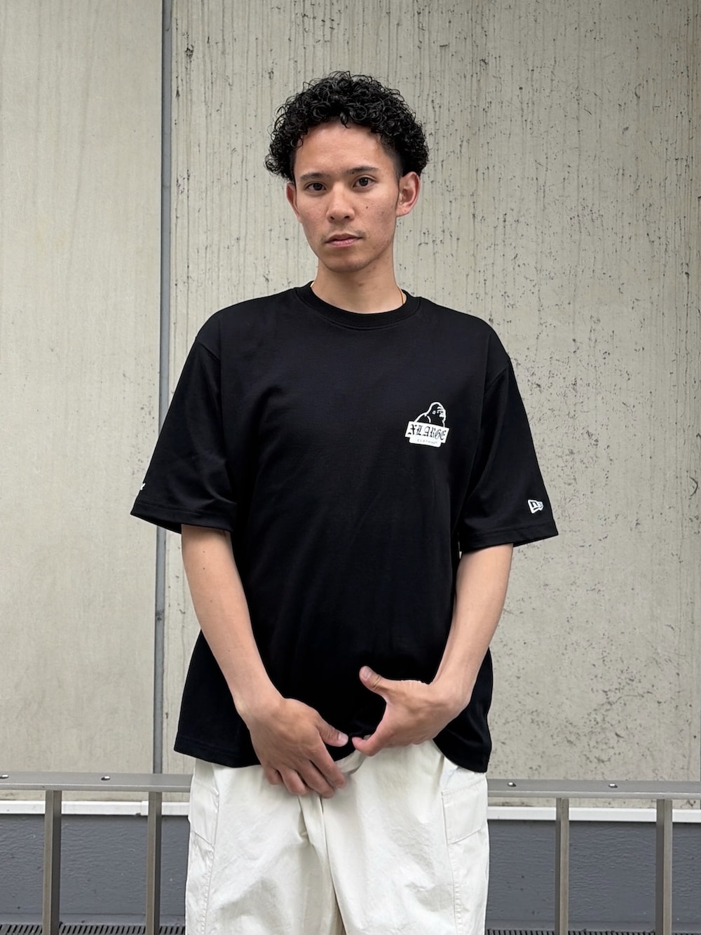 ブラック系のTシャツ/カットソー、ホワイト系のカーゴパンツを着用したメンズの夏コーディネートの6枚目の写真