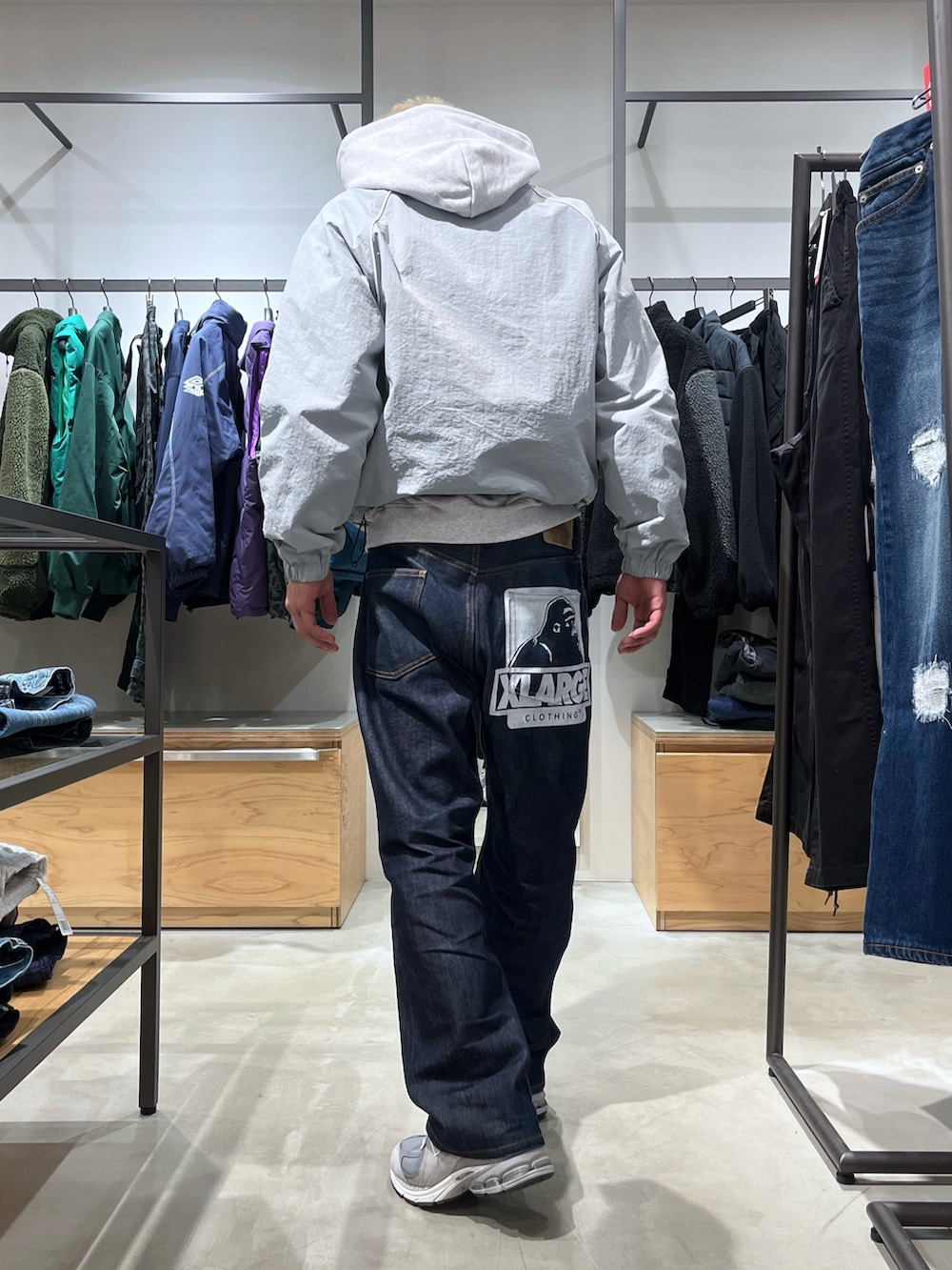 グレー系のナイロンジャケット、ブルー系のデニムパンツを着用したメンズの冬コーディネートの4枚目の写真