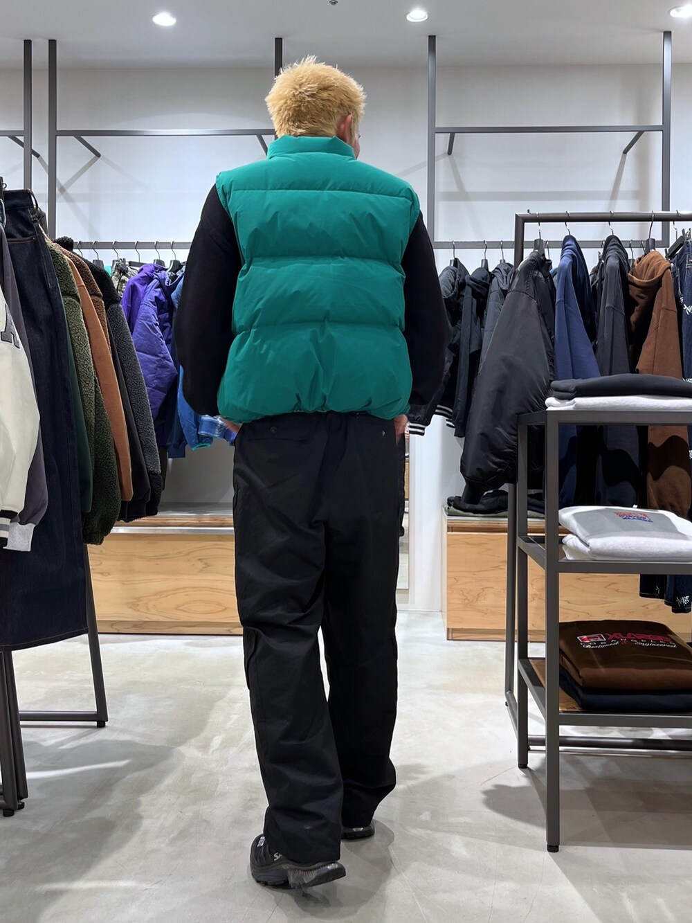 ブラック系のニット/セーター、グリーン系のダウンベスト、ブラック系のカーゴパンツを着用したメンズの秋コーディネートの4枚目の写真