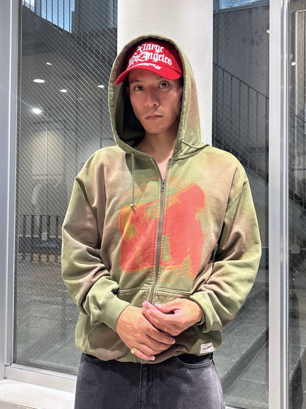 ブラック系のデニムジャケット、グリーン系のパーカー、ブラウン系のデニムパンツを着用したメンズの秋コーディネートの5枚目の写真