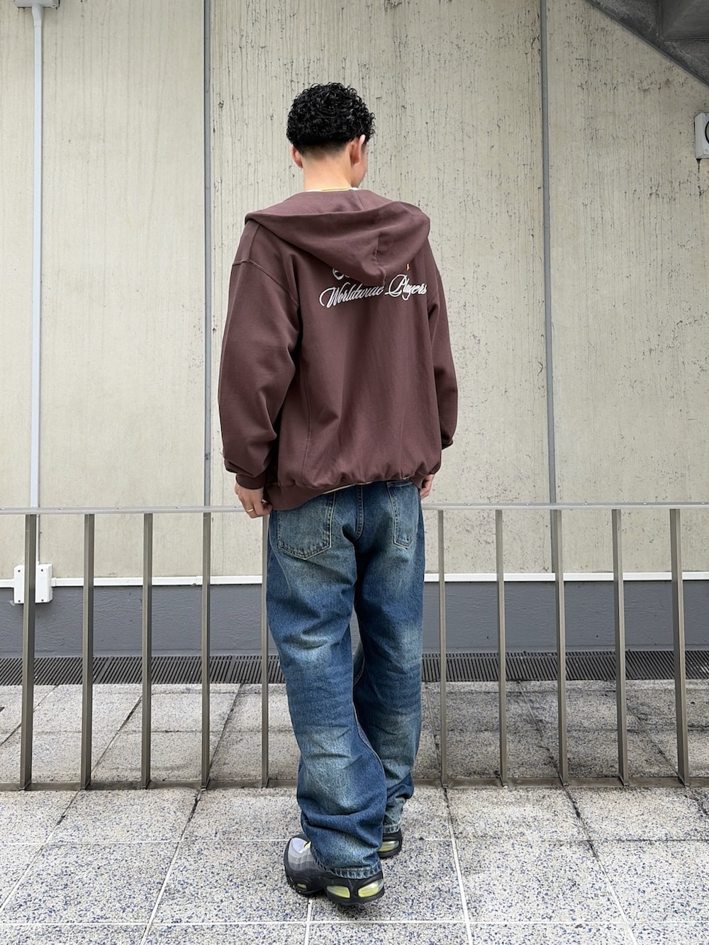 ベージュ系のTシャツ/カットソー、ブラウン系のパーカー、ブルー系のデニムパンツを着用したメンズの春コーディネートの4枚目の写真