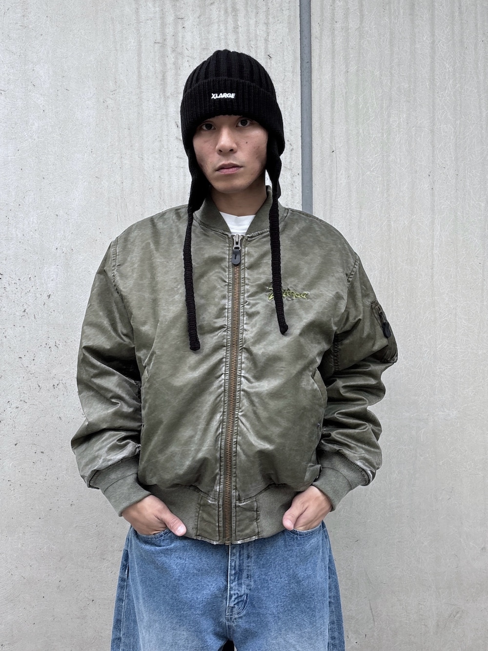 ブラック系のMA-1、ブルー系のデニムパンツ、ブラック系のニットキャップ/ビーニーを着用したメンズの秋コーディネートの5枚目の写真