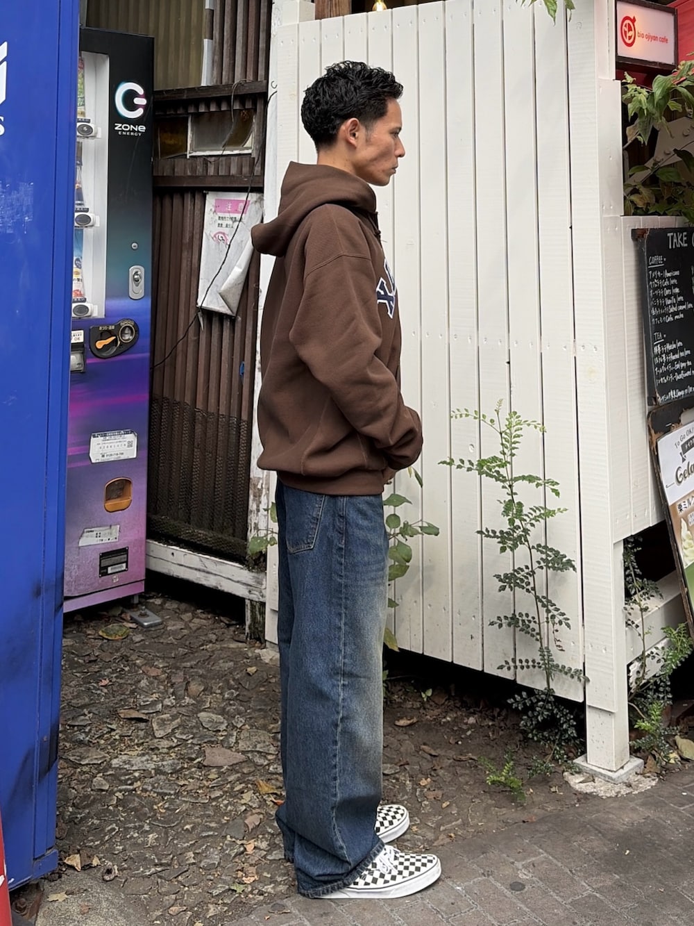 グレー系のパーカー、ブルー系のデニムパンツを着用したメンズの秋コーディネートの4枚目の写真