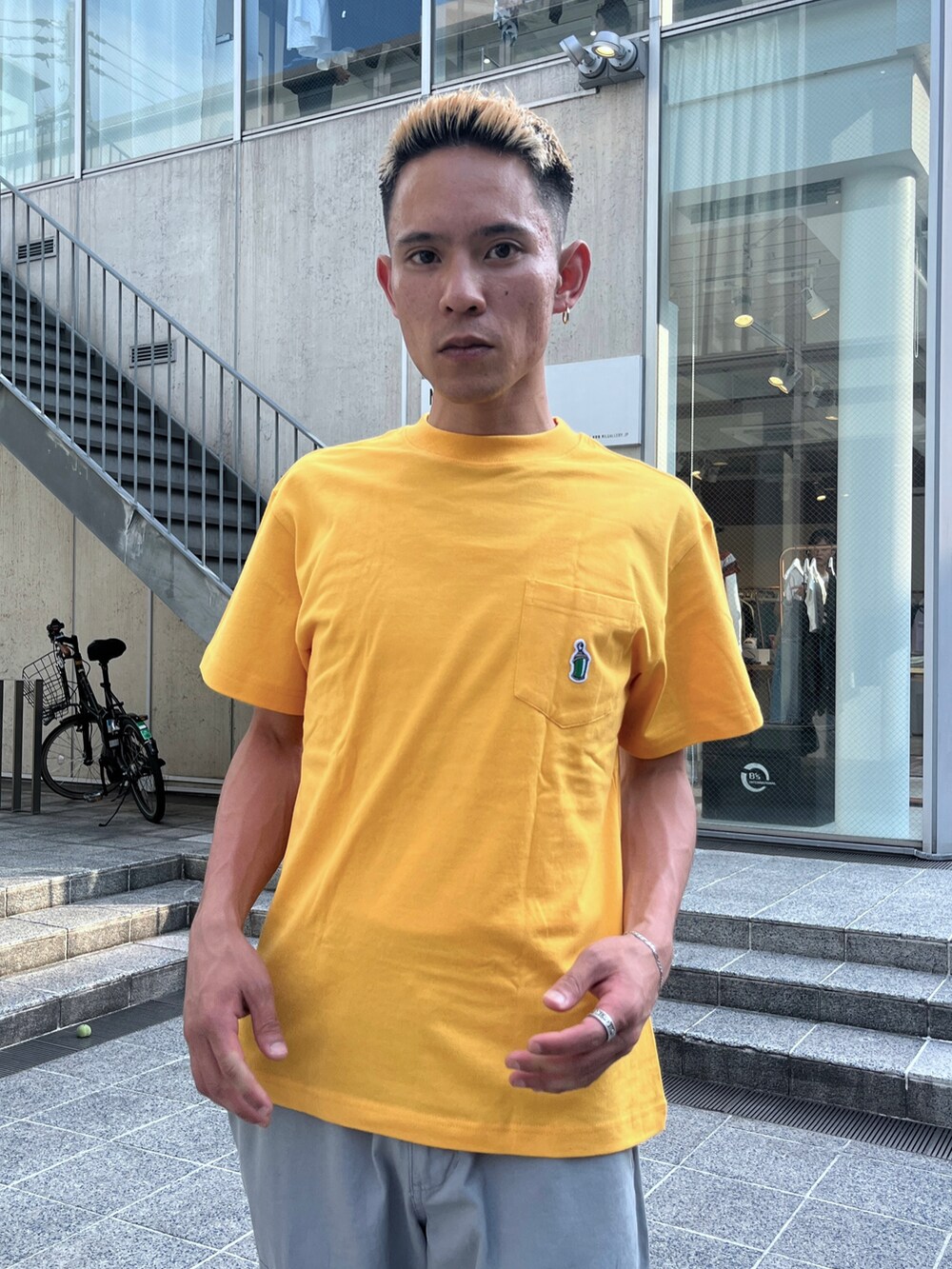イエロー系のTシャツ/カットソー、グレー系のカーゴパンツを着用したメンズの夏コーディネートの2枚目の写真