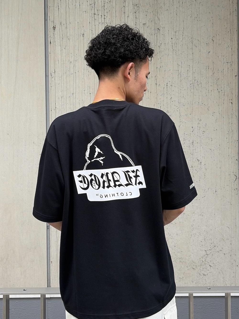 ブラック系のTシャツ/カットソー、ホワイト系のカーゴパンツを着用したメンズの夏コーディネートの7枚目の写真