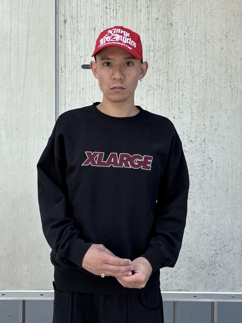 ブラック系のスウェット、ブラック系のスウェットパンツ、レッド系のキャップを着用したメンズの秋コーディネートの5枚目の写真