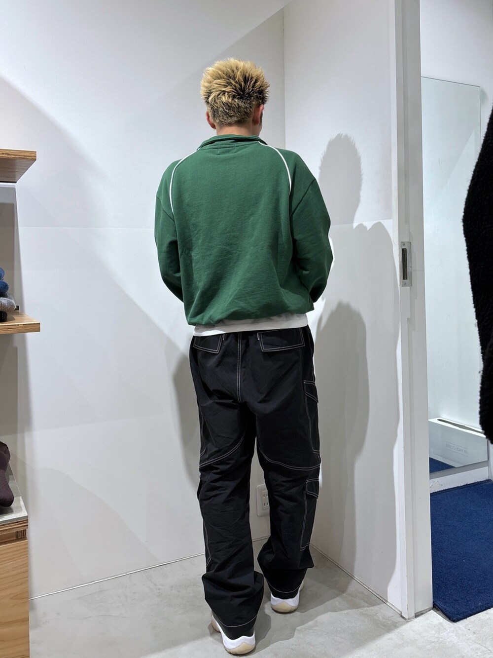 グリーン系のスウェット、ブラック系のカーゴパンツを着用したメンズの冬コーディネートの4枚目の写真