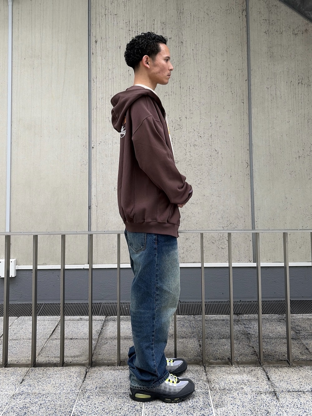 ベージュ系のTシャツ/カットソー、ブラウン系のパーカー、ブルー系のデニムパンツを着用したメンズの春コーディネートの3枚目の写真