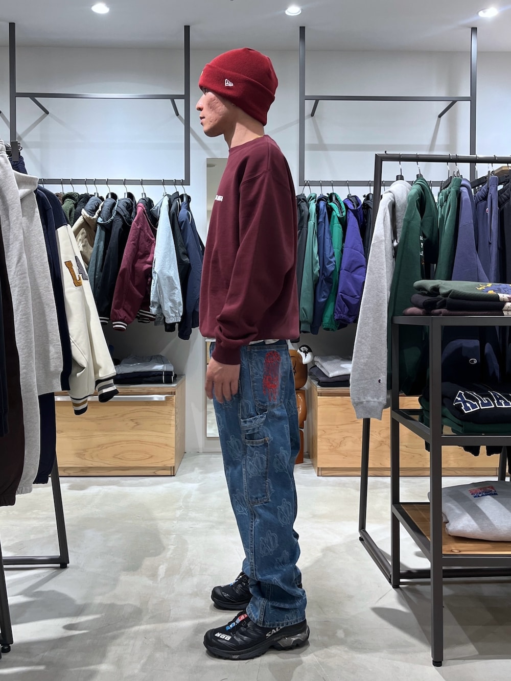 レッド系のスウェット、ブルー系のデニムパンツ、レッド系のニットキャップ/ビーニーを着用したメンズの冬コーディネートの3枚目の写真