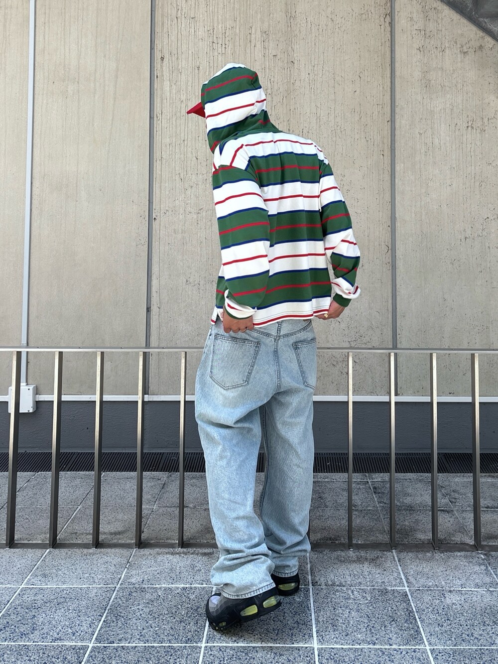 ホワイト系のTシャツ/カットソー、ブラック系のデニムパンツ、レッド系のキャップを着用したメンズの秋コーディネートの4枚目の写真