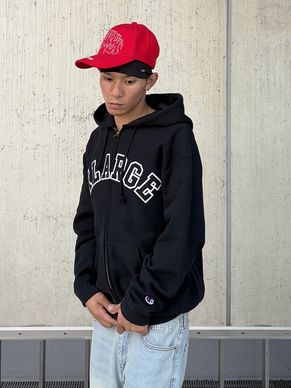 ブラック系のパーカー、ブルー系のデニムパンツ、レッド系のキャップを着用したメンズの秋コーディネートの7枚目の写真