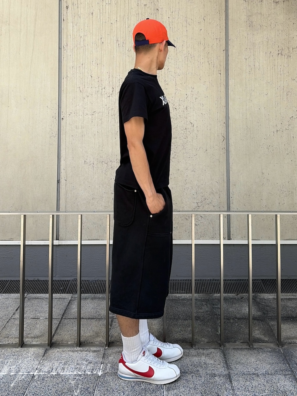 ピンク系のTシャツ/カットソー、グレー系のスウェットパンツ、オレンジ系のキャップを着用したメンズの夏コーディネートの3枚目の写真
