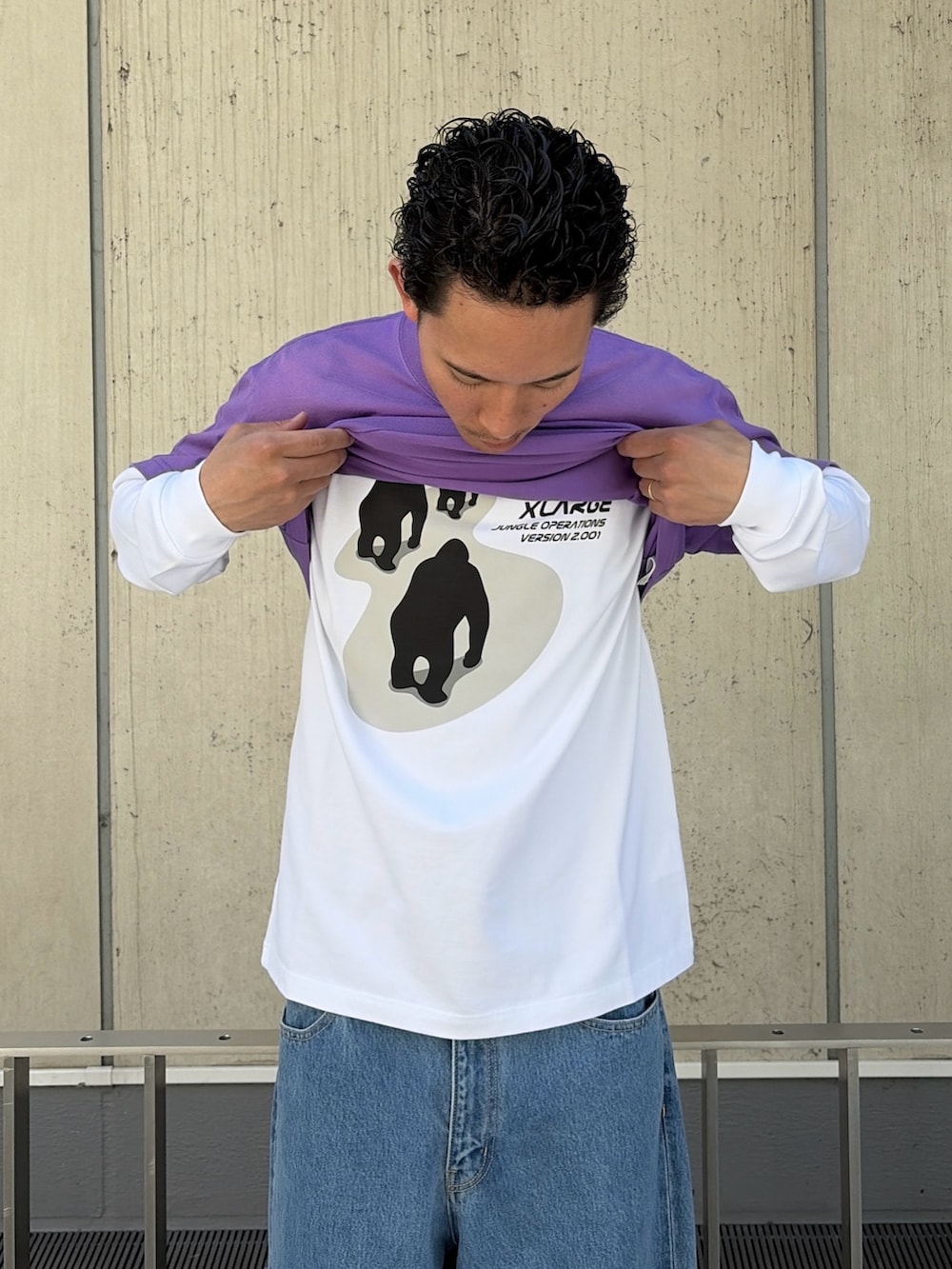 パープル系のTシャツ/カットソー、ホワイト系のTシャツ/カットソー、ブルー系のデニムパンツを着用したメンズの春コーディネートの7枚目の写真