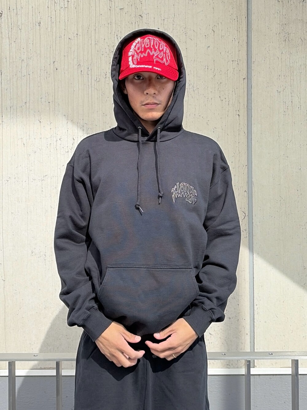 ブラック系のパーカー、ブラック系のその他パンツ、レッド系のキャップを着用したメンズの夏コーディネートの9枚目の写真