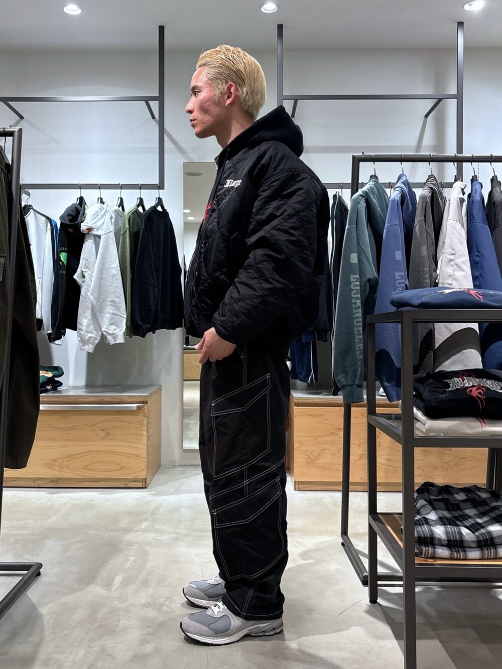 ブラック系のカーゴパンツ、ブラック系のブルゾン、ブラック系のパーカーを着用したメンズの冬コーディネートの2枚目の写真