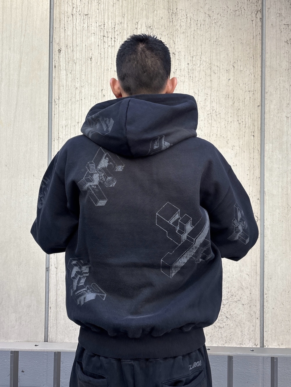 ブラック系のパーカー、ブラック系のスウェットパンツを着用したメンズの冬コーディネートの6枚目の写真