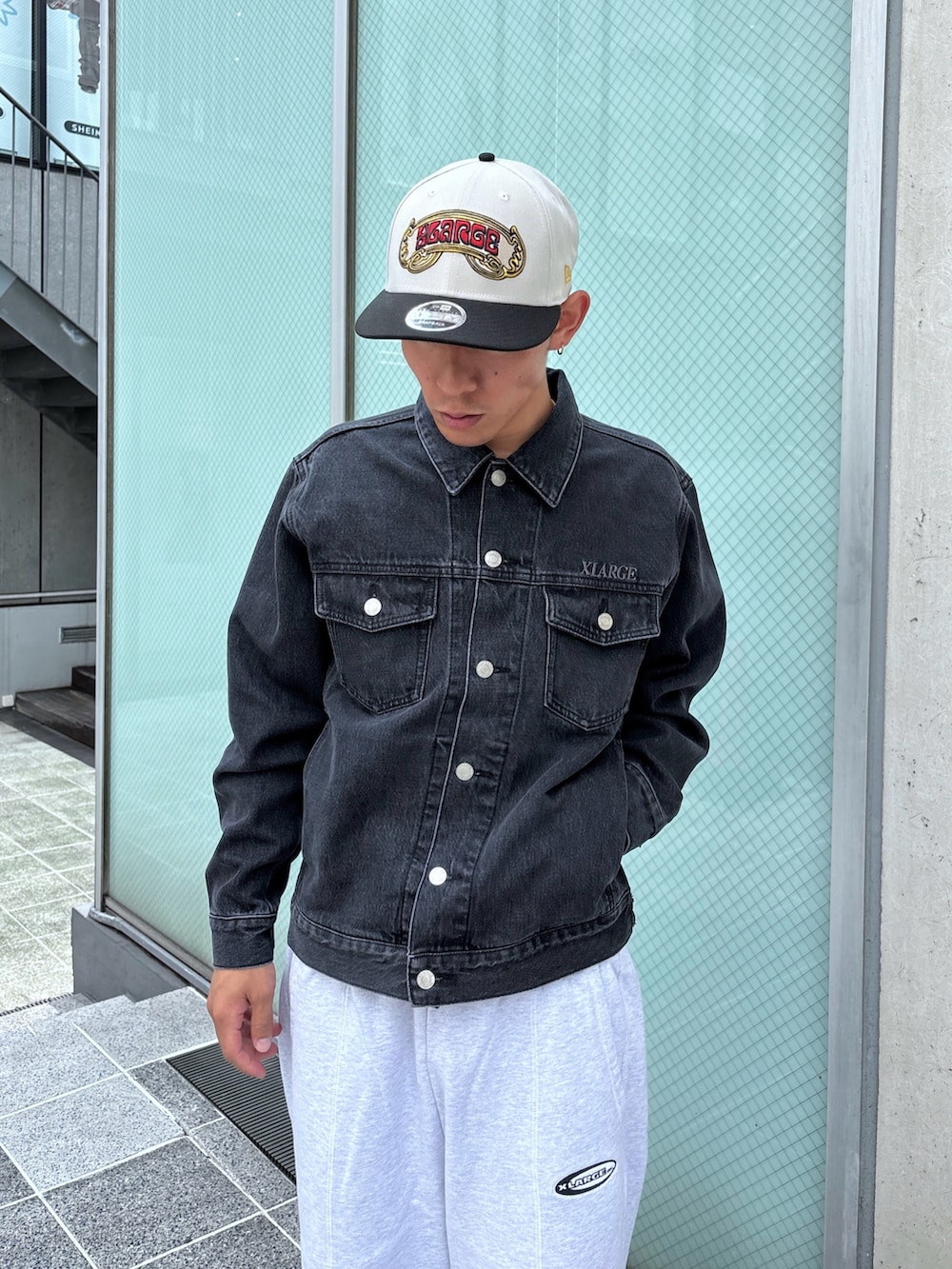 ブラック系のデニムジャケット、グレー系のスウェットパンツ、ホワイト系のキャップを着用したメンズの秋コーディネートの6枚目の写真