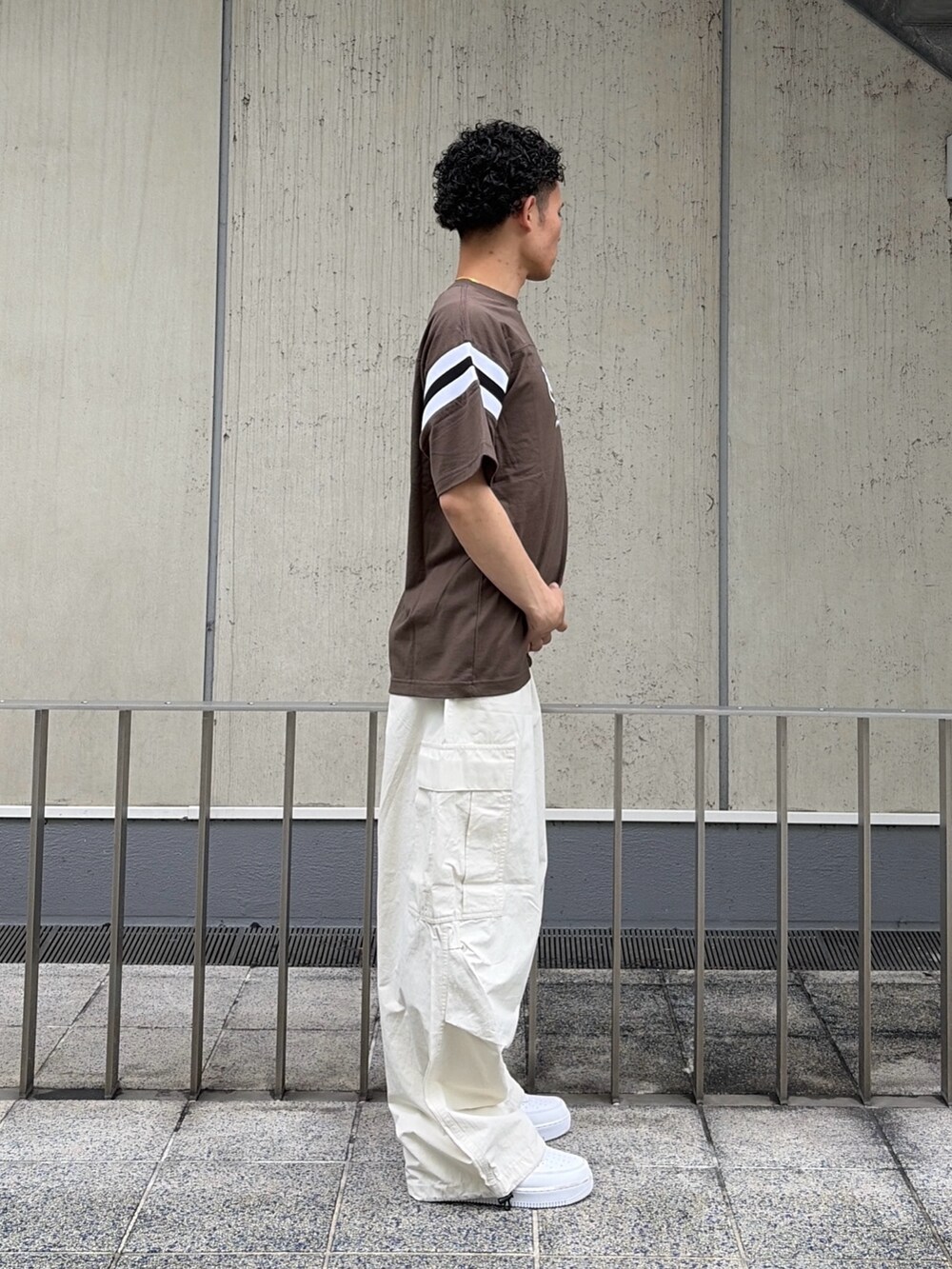 ブラウン系のTシャツ/カットソー、ホワイト系のカーゴパンツを着用したメンズの夏コーディネートの3枚目の写真
