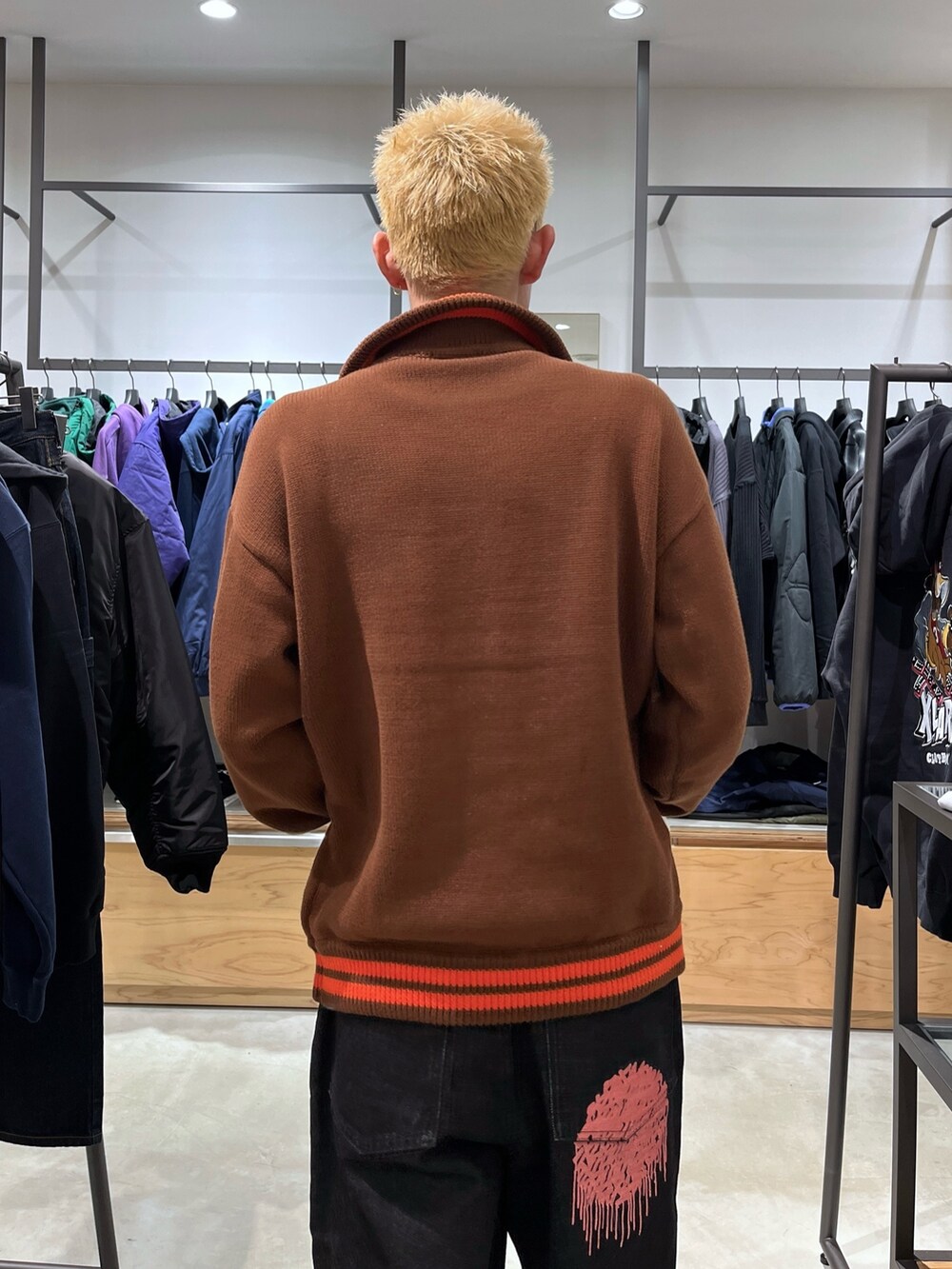 ブラック系のデニムパンツ、ブラウン系のニット/セーターを着用したメンズの秋コーディネートの7枚目の写真