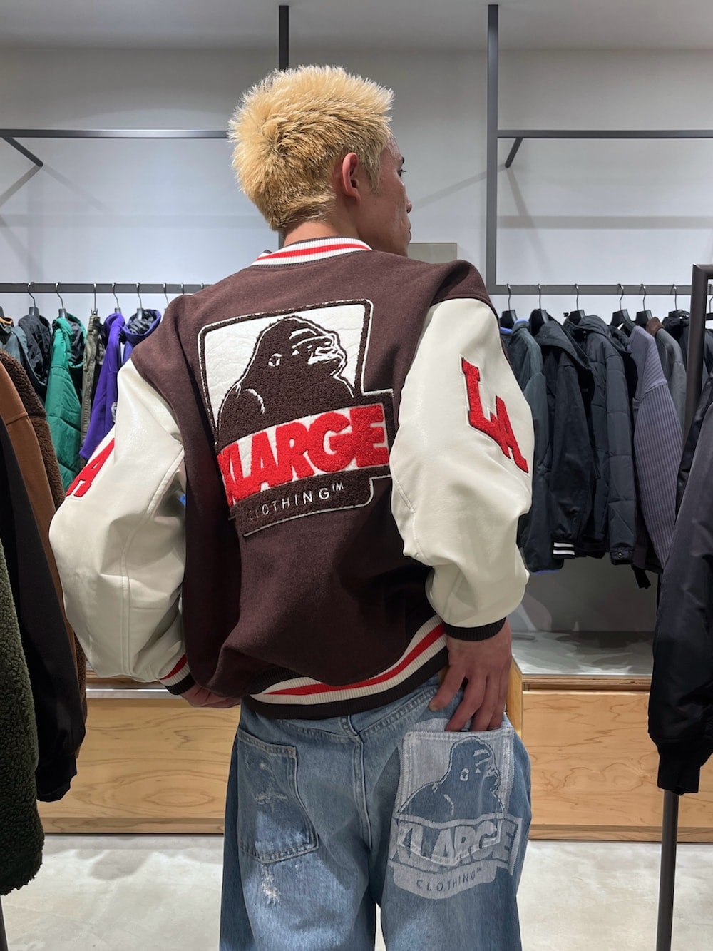 ブラウン系のスタジャン、ブルー系のデニムパンツを着用したメンズの秋コーディネートの6枚目の写真