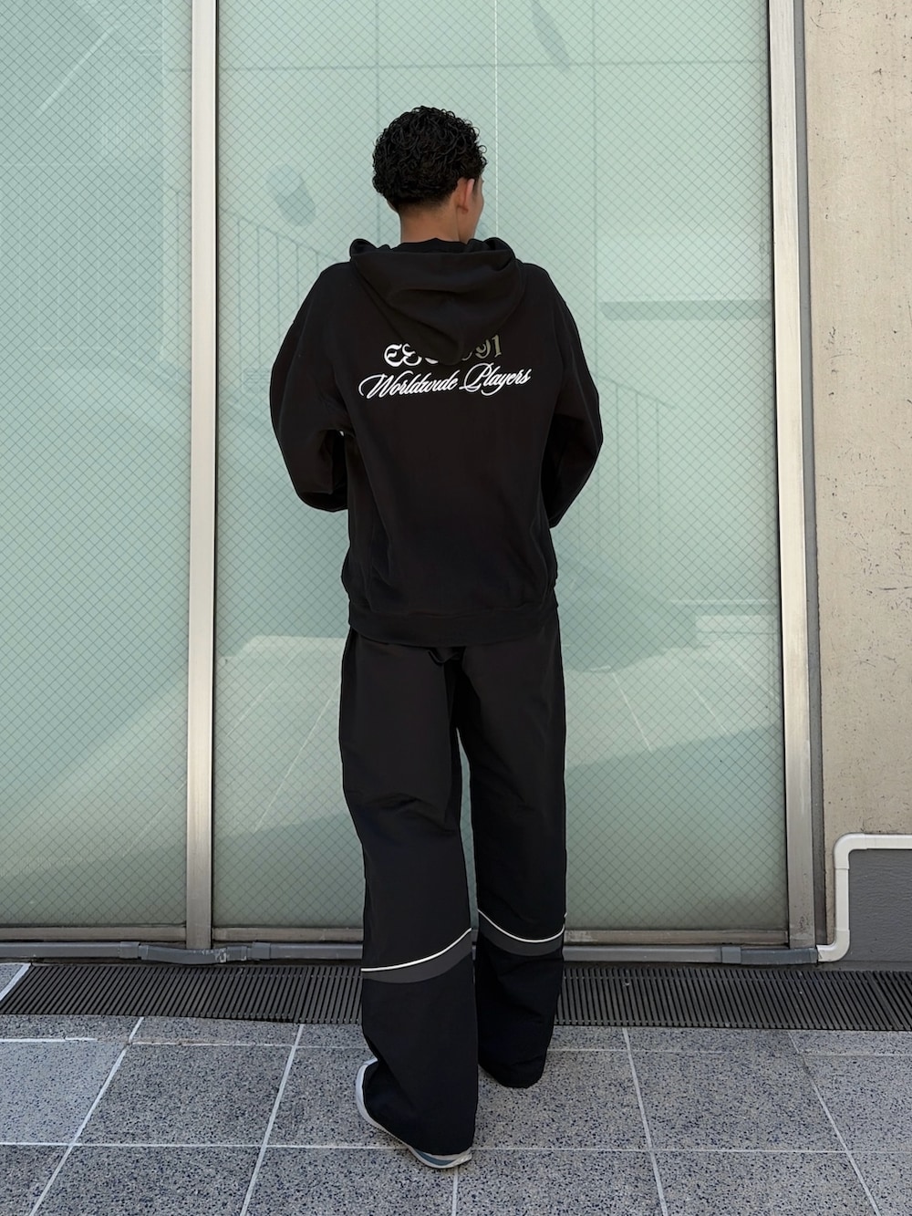 ブラウン系のパーカー、ブラック系のその他パンツを着用したメンズの春コーディネートの4枚目の写真