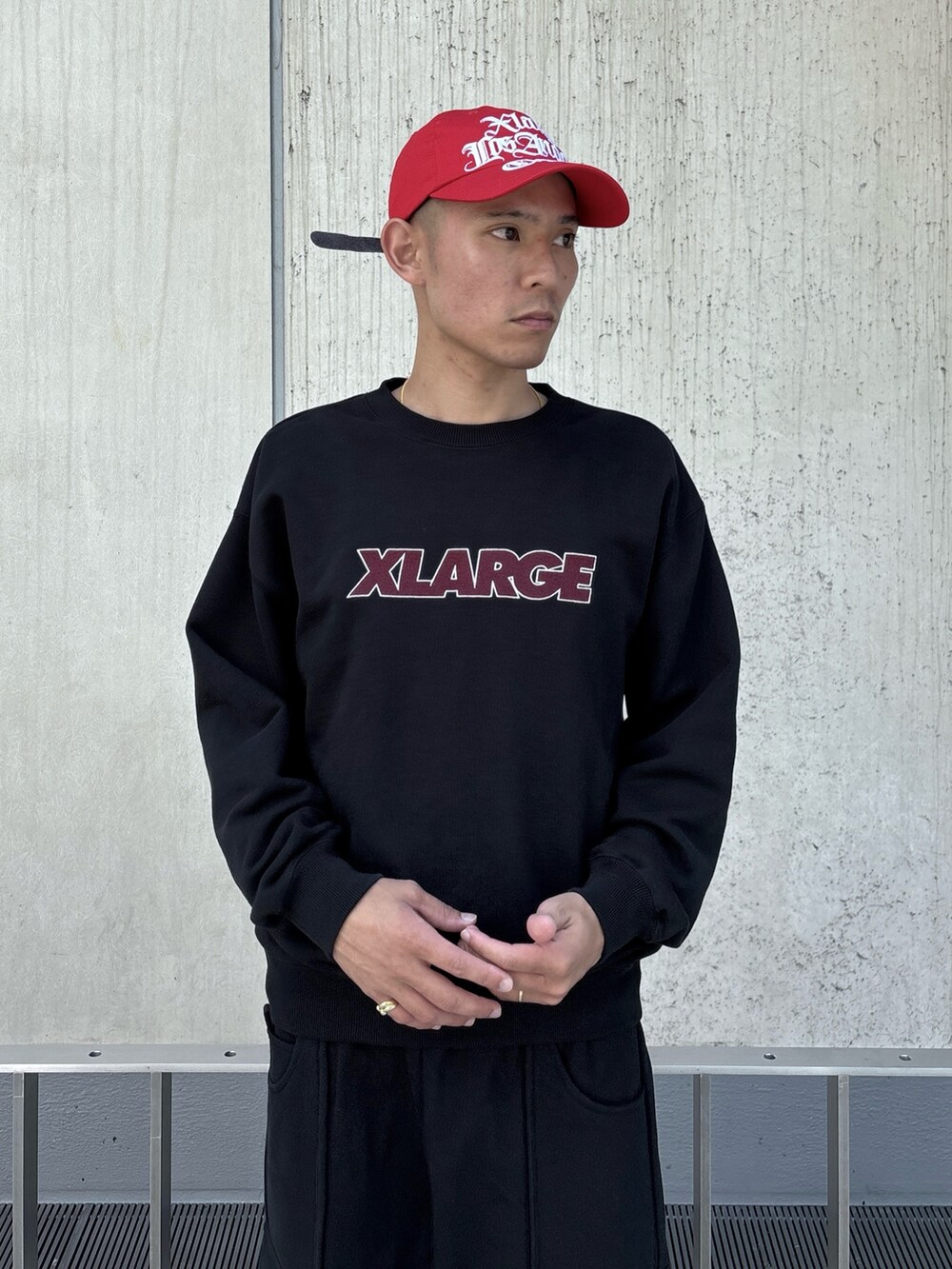 ブラック系のスウェット、ブラック系のスウェットパンツ、レッド系のキャップを着用したメンズの秋コーディネートの6枚目の写真