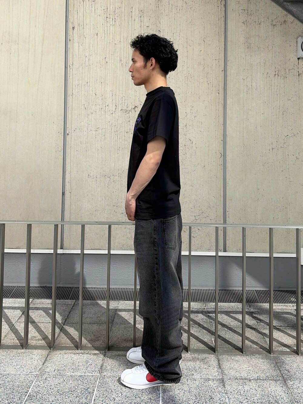 ブラック系のTシャツ/カットソー、ブルー系のデニムパンツを着用したメンズの春コーディネートの2枚目の写真