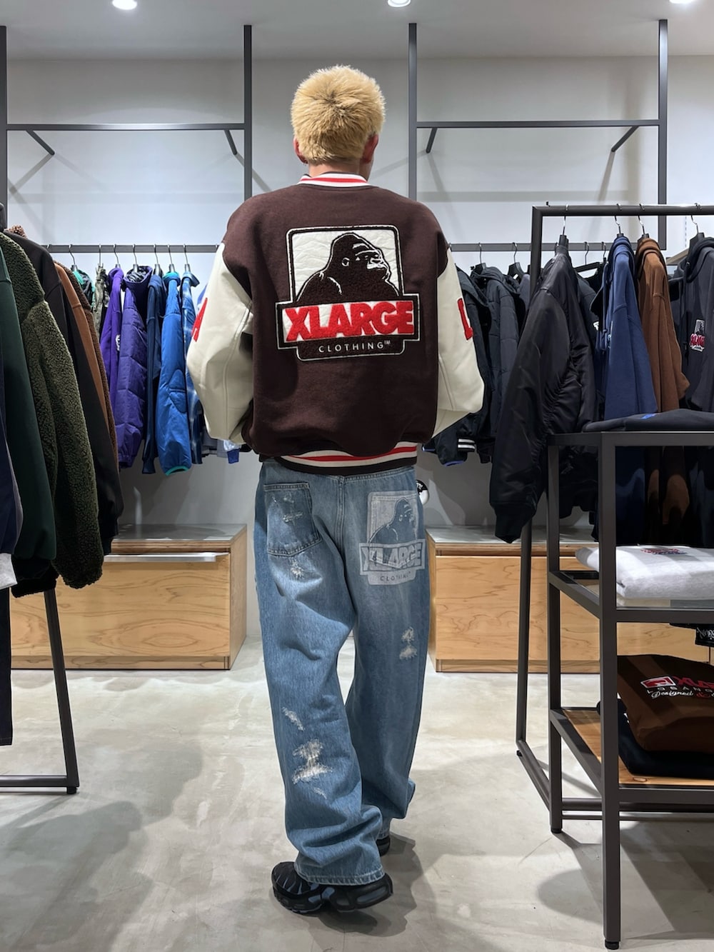 ブラウン系のスタジャン、ブルー系のデニムパンツを着用したメンズの秋コーディネートの4枚目の写真