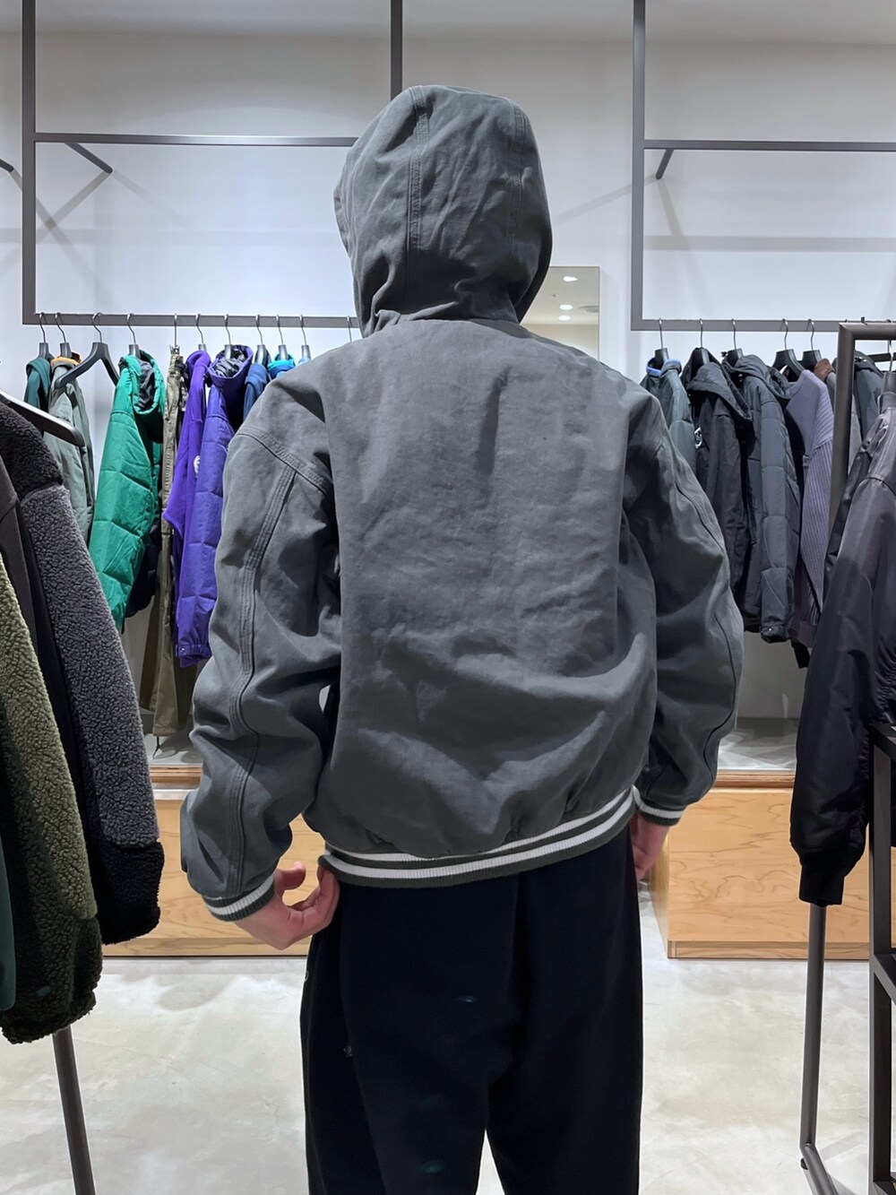 グリーン系のブルゾン、グレー系のスウェットパンツを着用したメンズの秋コーディネートの7枚目の写真