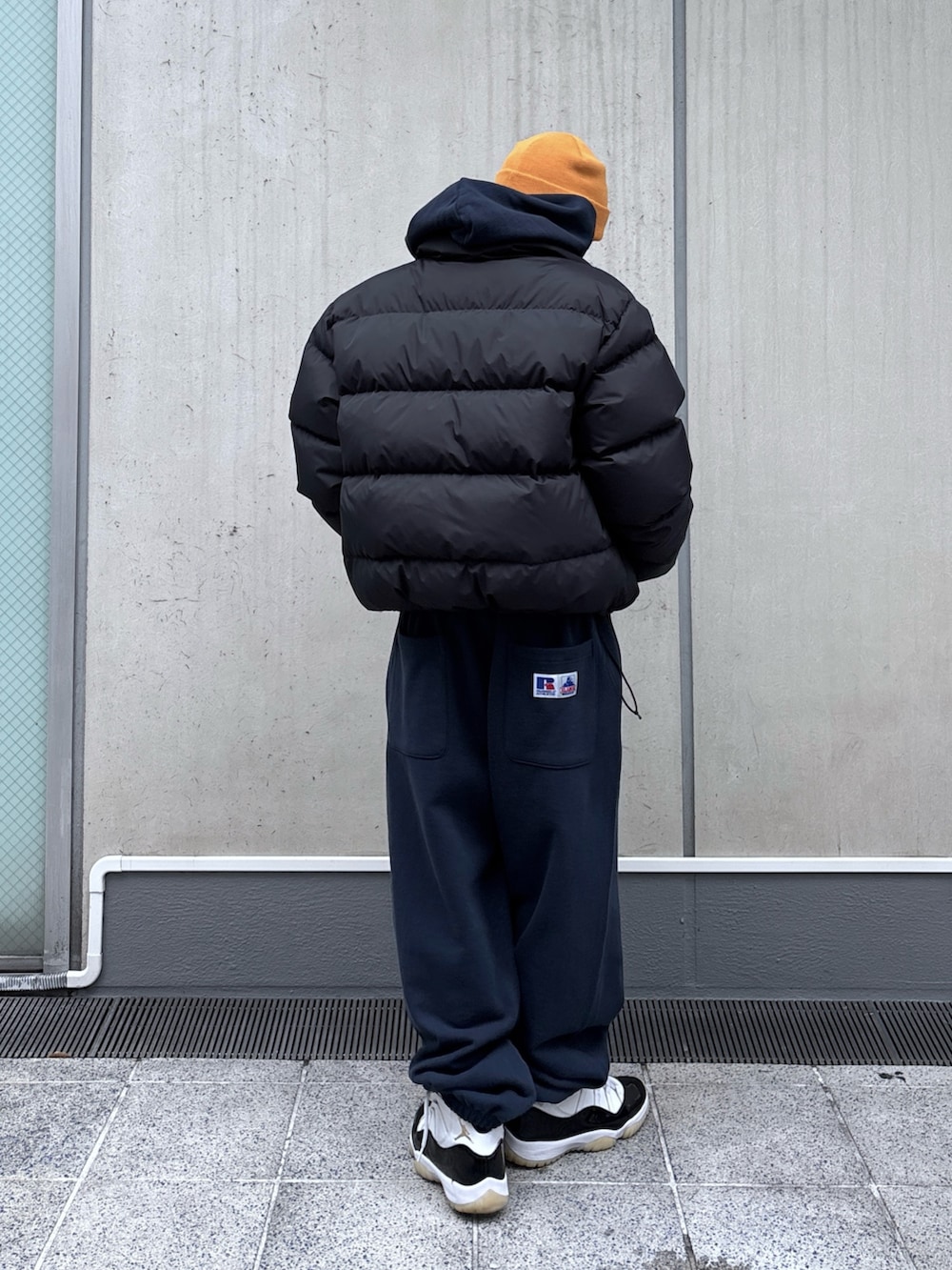 ブラック系のダウンジャケット/コート、ブルー系のパーカー、ブルー系のスウェットパンツを着用したメンズの秋コーディネートの5枚目の写真