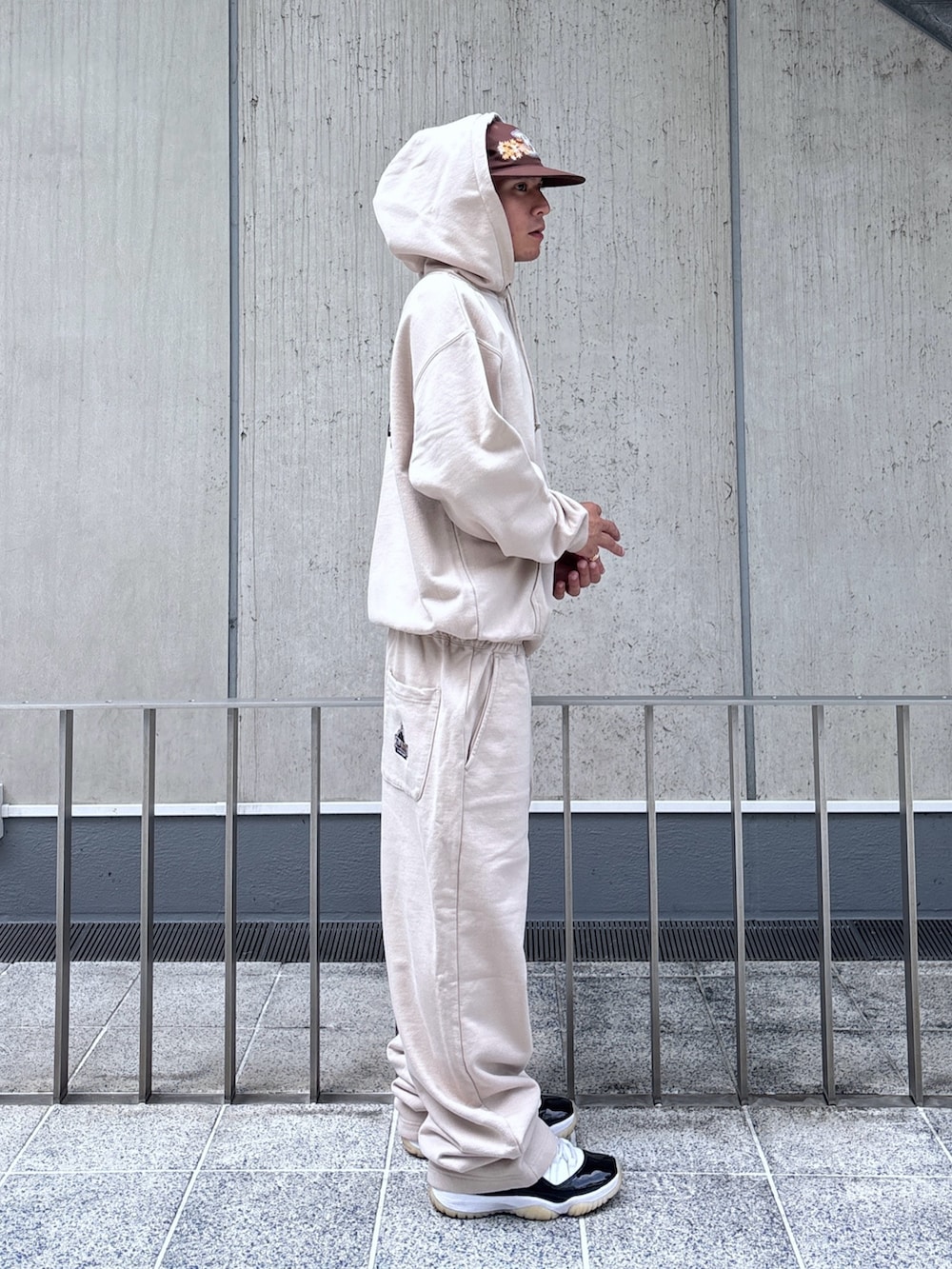 ベージュ系のスウェットパンツ、ベージュ系のパーカー、ブラウン系のキャップを着用したメンズの秋コーディネートの4枚目の写真