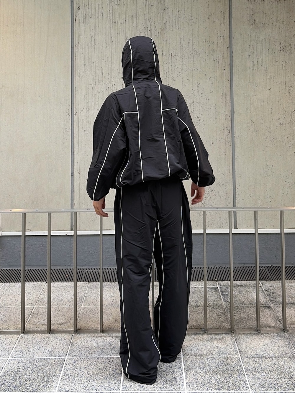 ブラック系のブルゾン、ブラック系のその他パンツ、レッド系のニットキャップ/ビーニーを着用したメンズの秋コーディネートの5枚目の写真
