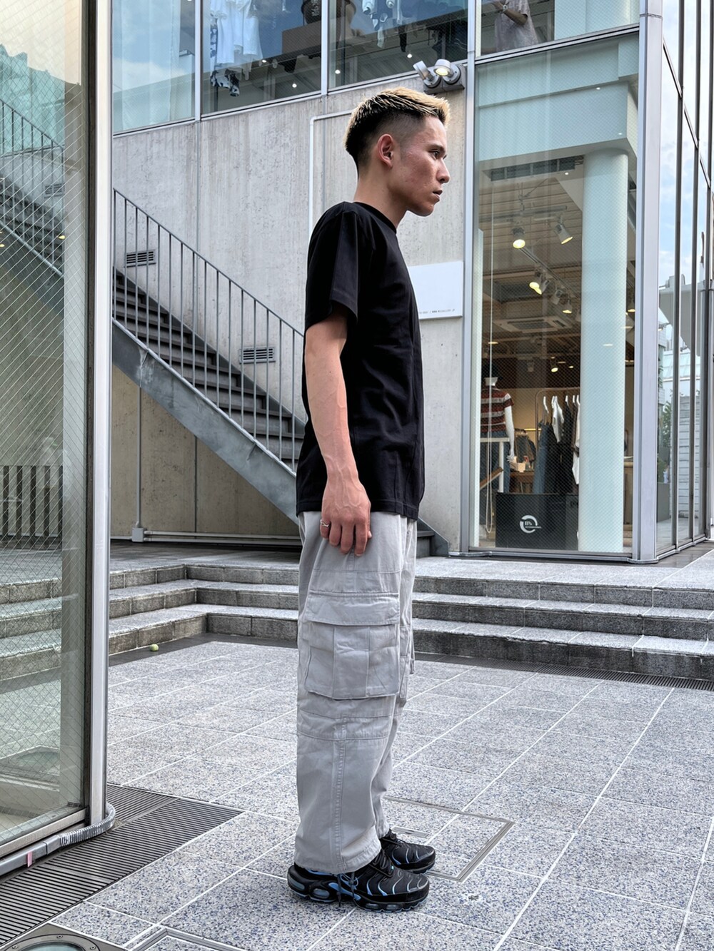 ブラック系のTシャツ/カットソー、グレー系のカーゴパンツを着用したメンズの夏コーディネートの3枚目の写真