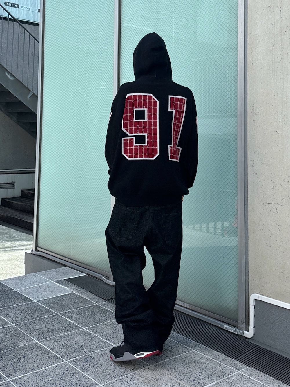 ブラック系のニット/セーター、ブラック系のデニムパンツ、ブラック系のその他アウターを着用したメンズの秋コーディネートの10枚目の写真