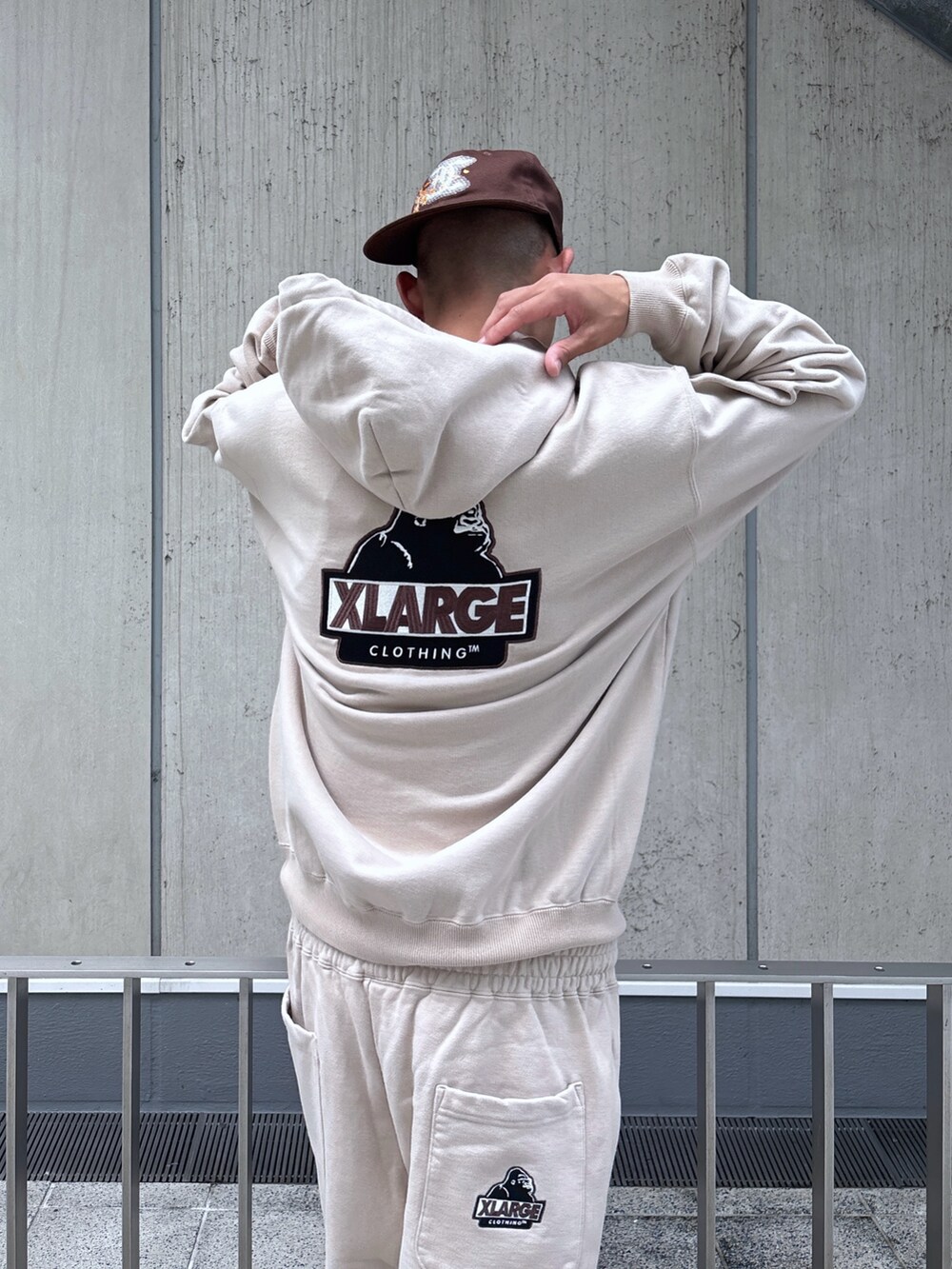 ベージュ系のスウェットパンツ、ベージュ系のパーカー、ブラウン系のキャップを着用したメンズの秋コーディネートの9枚目の写真