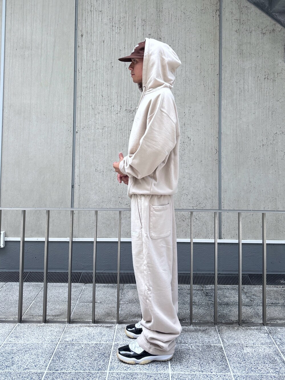 ベージュ系のスウェットパンツ、ベージュ系のパーカー、ブラウン系のキャップを着用したメンズの秋コーディネートの3枚目の写真