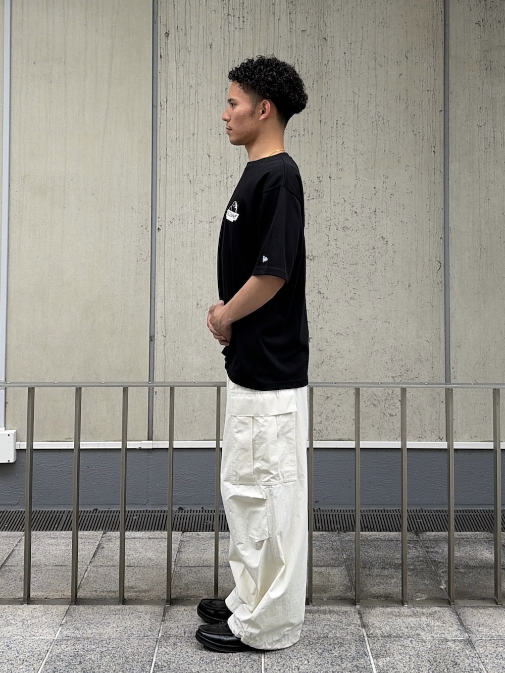 ブラック系のTシャツ/カットソー、ホワイト系のカーゴパンツを着用したメンズの夏コーディネートの2枚目の写真