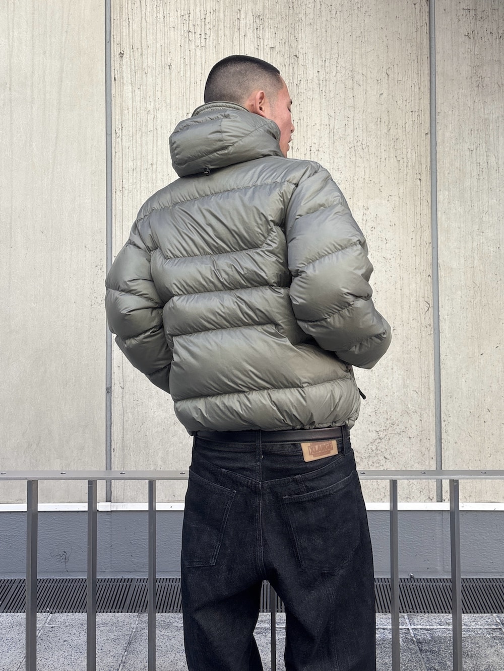 グリーン系のダウンジャケット/コート、ブラック系のデニムパンツを着用したメンズの秋コーディネートの7枚目の写真