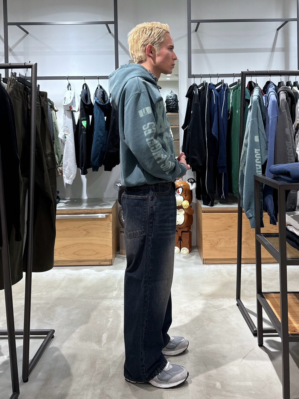 グリーン系のパーカー、ブルー系のデニムパンツを着用したメンズの冬コーディネートの3枚目の写真