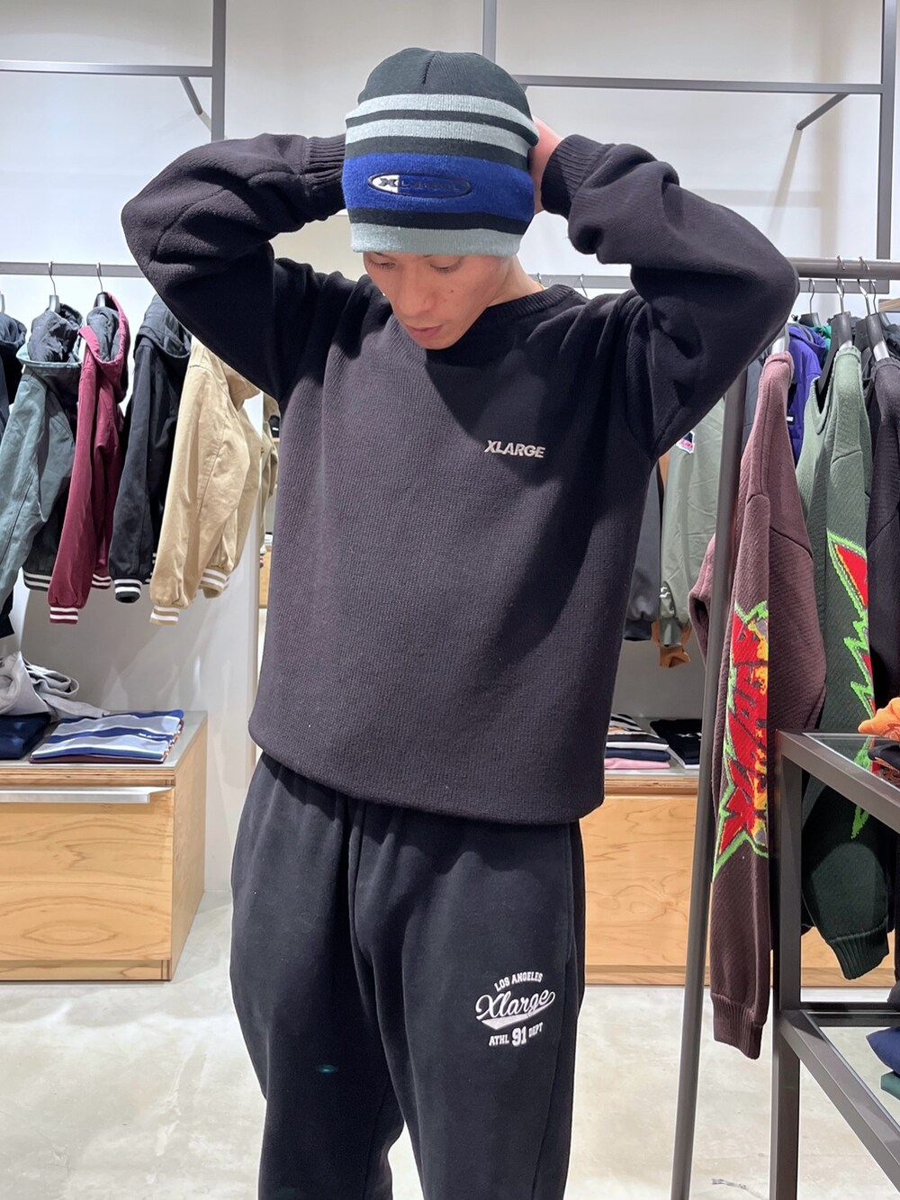 グレー系のスウェットパンツ、ブルー系のベスト、ブラック系のニット/セーターを着用したメンズの秋コーディネートの9枚目の写真