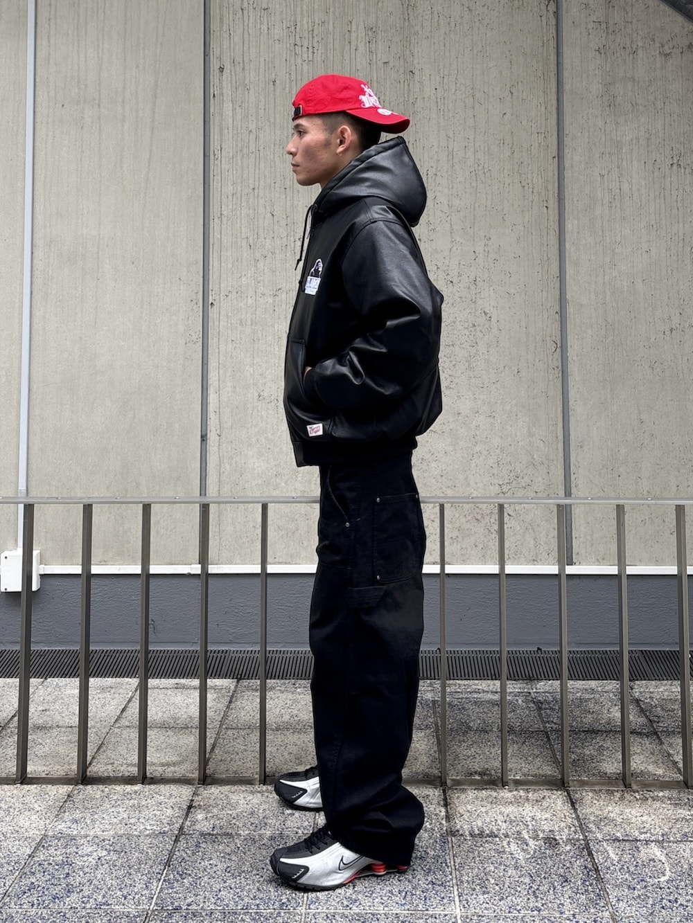 ブラック系のその他アウター、ブラウン系のその他パンツ、レッド系のキャップを着用したメンズの冬コーディネートの2枚目の写真